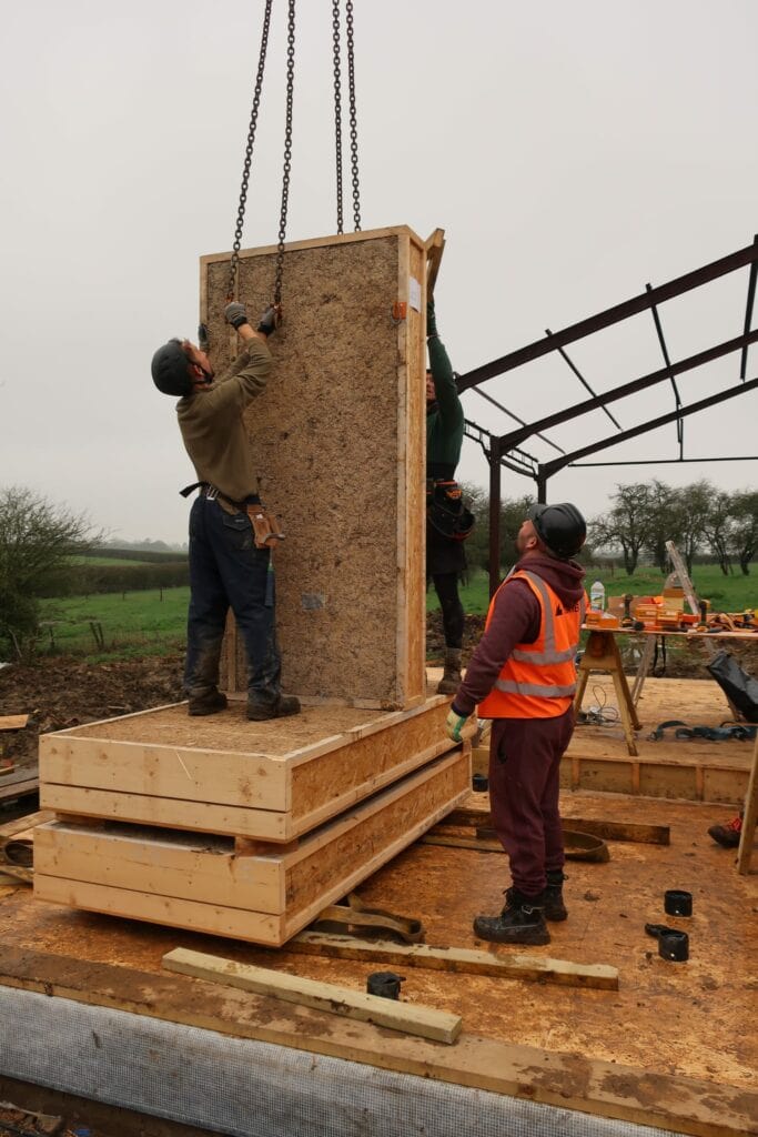 Installing a prefabricated hemp panel at Flat House, Margent Farm, Cambridgeshire, by Material Cultures